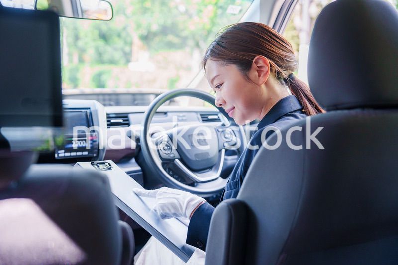 笑顔で運転をするタクシードライバーの女性