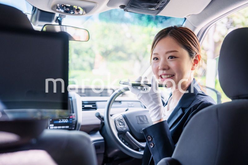 外国人への接客のために翻訳アプリを使う女性タクシードライバー