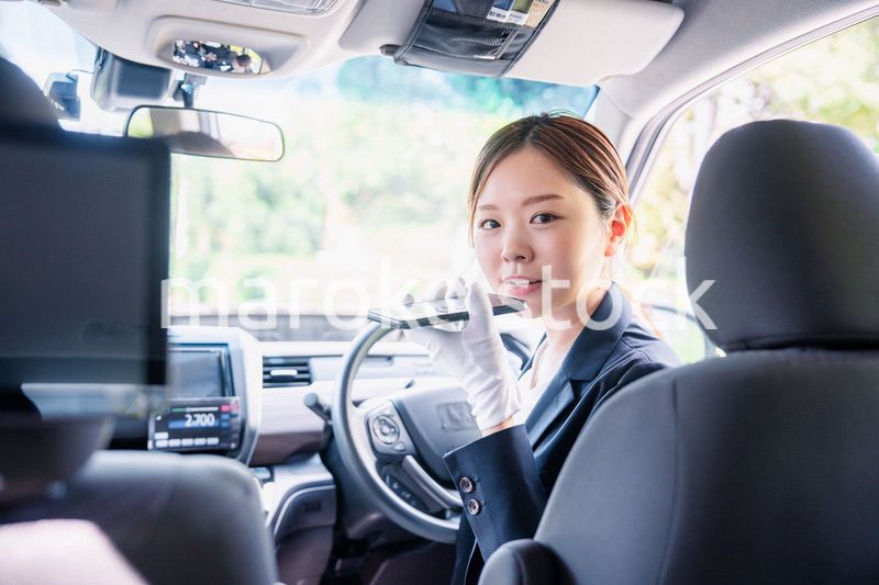 外国人への接客のために翻訳アプリを使う女性タクシードライバー