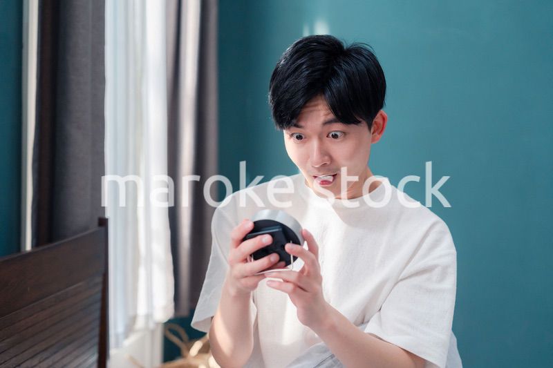 寝坊をして焦る若い男性