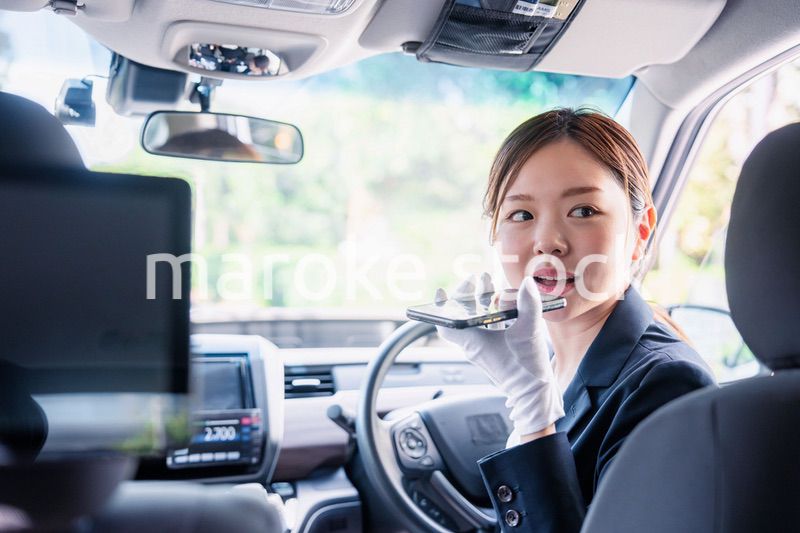 外国人への接客のために翻訳アプリを使う女性タクシードライバー