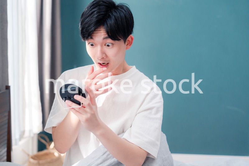 寝坊をして焦る若い男性