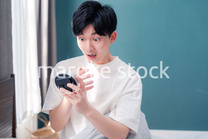 寝坊をして焦る若い男性