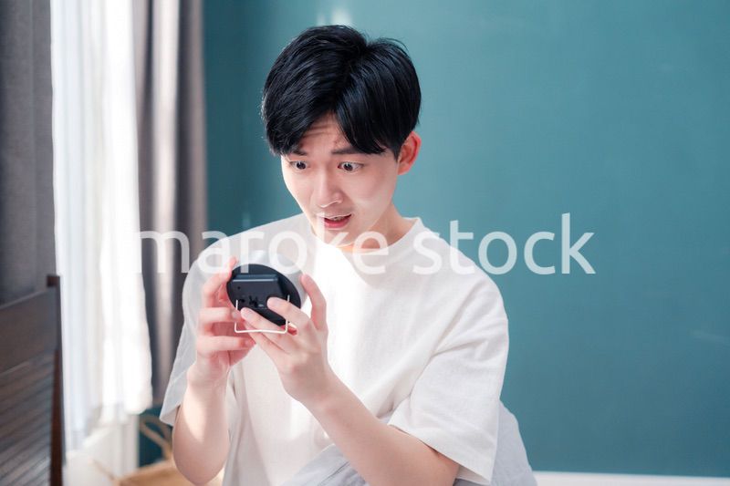 寝坊をして焦る若い男性