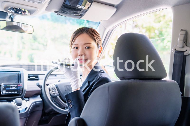 外国人への接客のために翻訳アプリを使う女性タクシードライバー