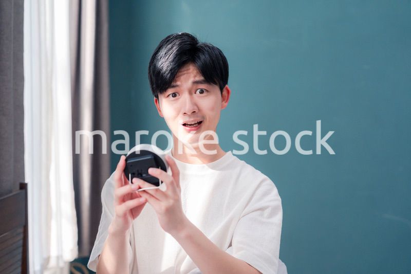 寝坊をして焦る若い男性