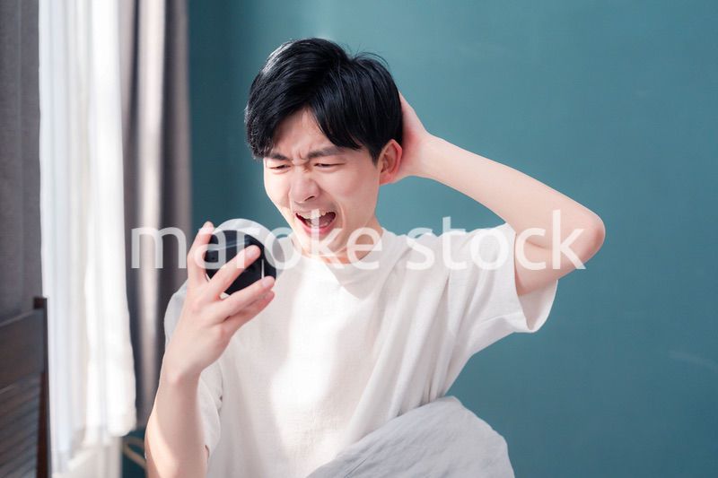 寝坊をして焦る若い男性