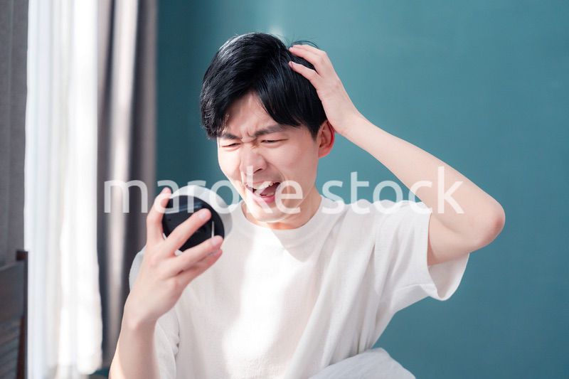 寝坊をして焦る若い男性