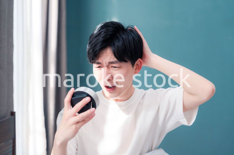 寝坊をして焦る若い男性