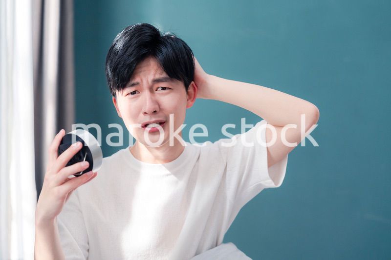 寝坊をして焦る若い男性