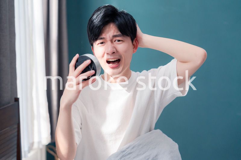 寝坊をして焦る若い男性