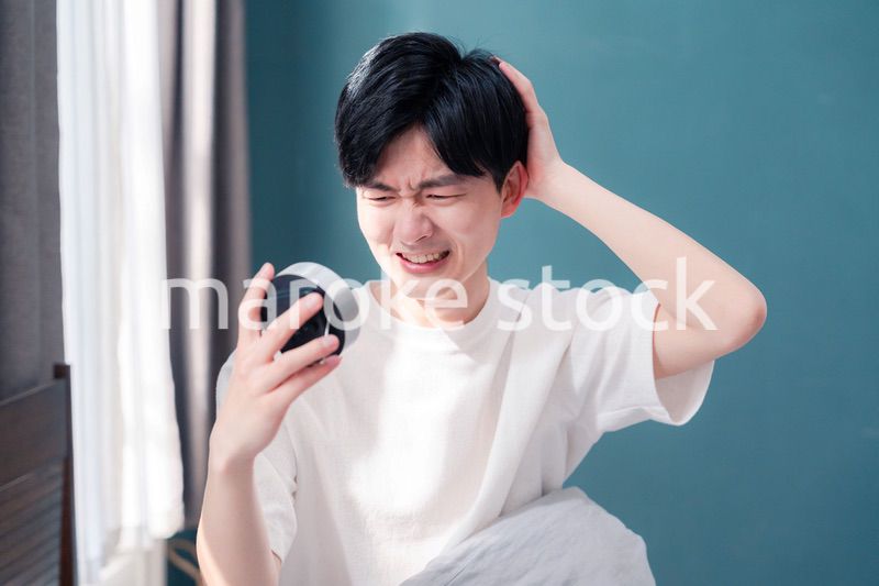 寝坊をして焦る若い男性