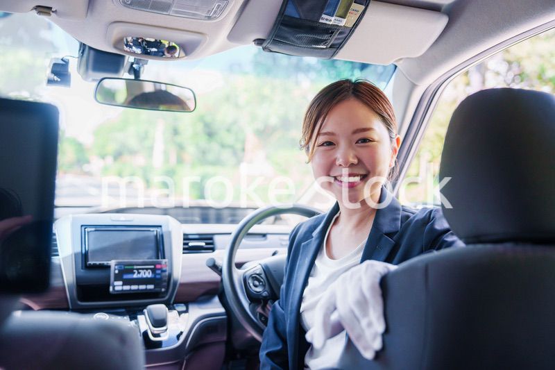 笑顔で運転をするタクシードライバーの女性