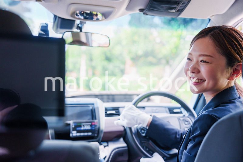 笑顔で運転をするタクシードライバーの女性