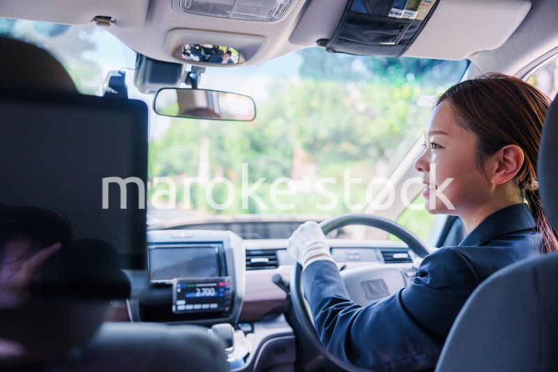 笑顔で運転をするタクシードライバーの女性