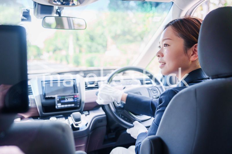 笑顔で運転をするタクシードライバーの女性