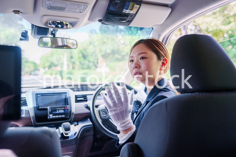 笑顔で運転をするタクシードライバーの女性