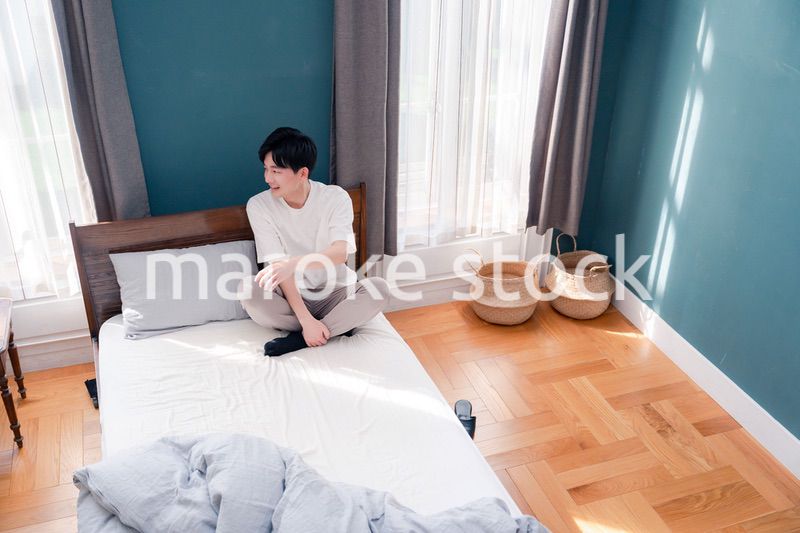 ベッドに座る若い男性