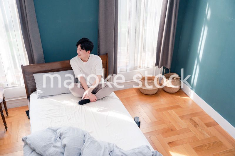 ベッドに座る若い男性