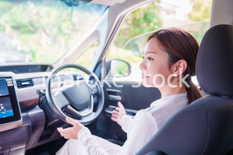 自動運転の車を運転する若い女性