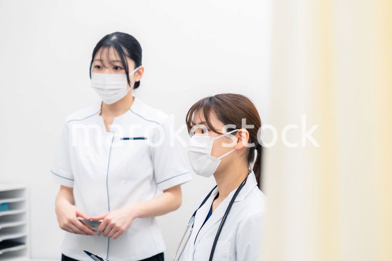 患者の治療をする2人の若い医療従事者