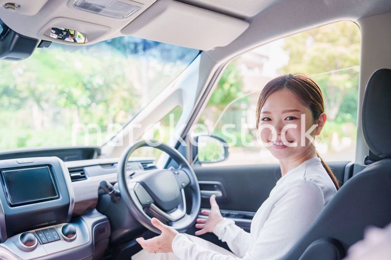 自動運転の車を笑顔で運転する女性