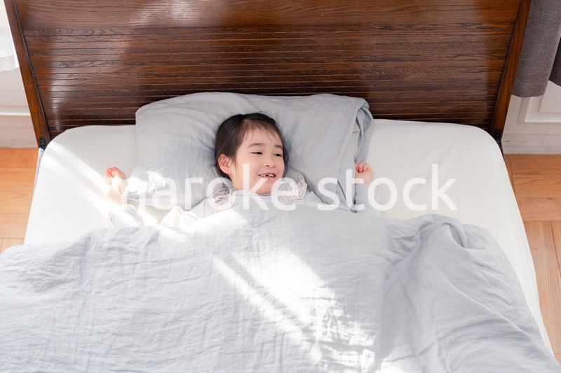 ベッドでぐっすりと寝る小さな女の子
