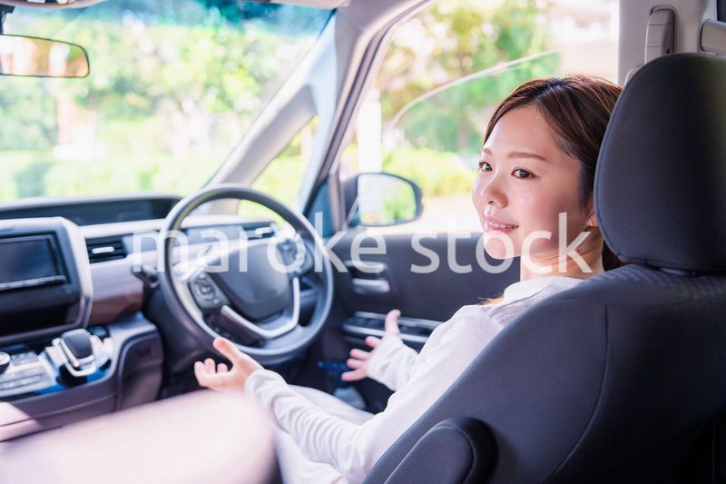 自動運転の車で手放し運転をする若い女性