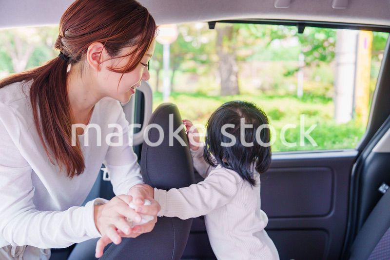車に子供を乗せるお母さん