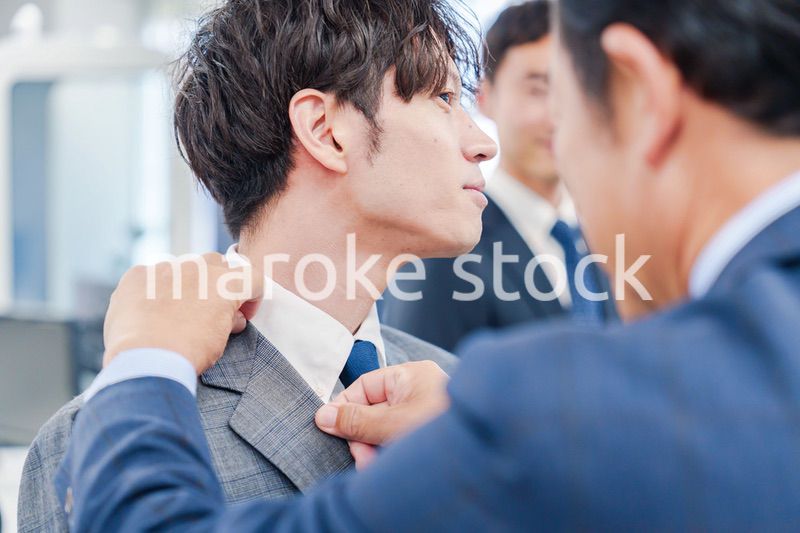 部下の身だしなみを整える上司