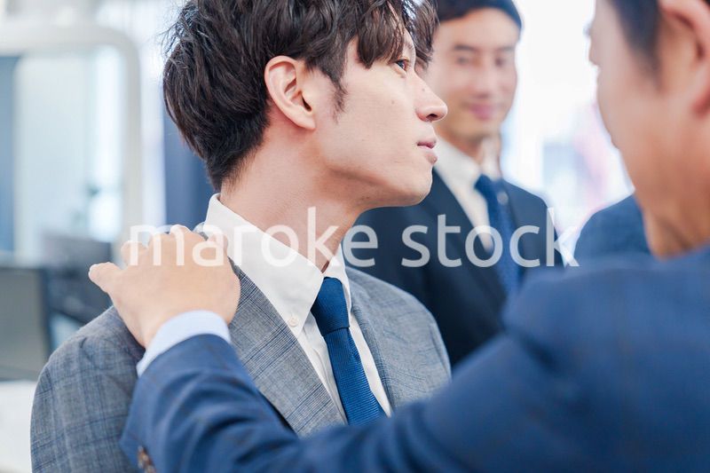 部下の身だしなみを整える上司