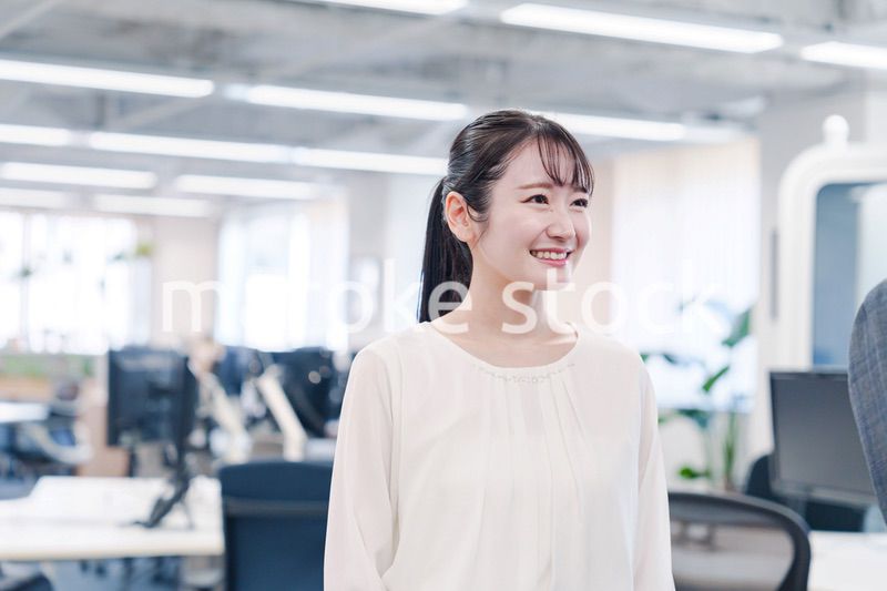 オフィスで楽しく働く若いキャリアウーマン