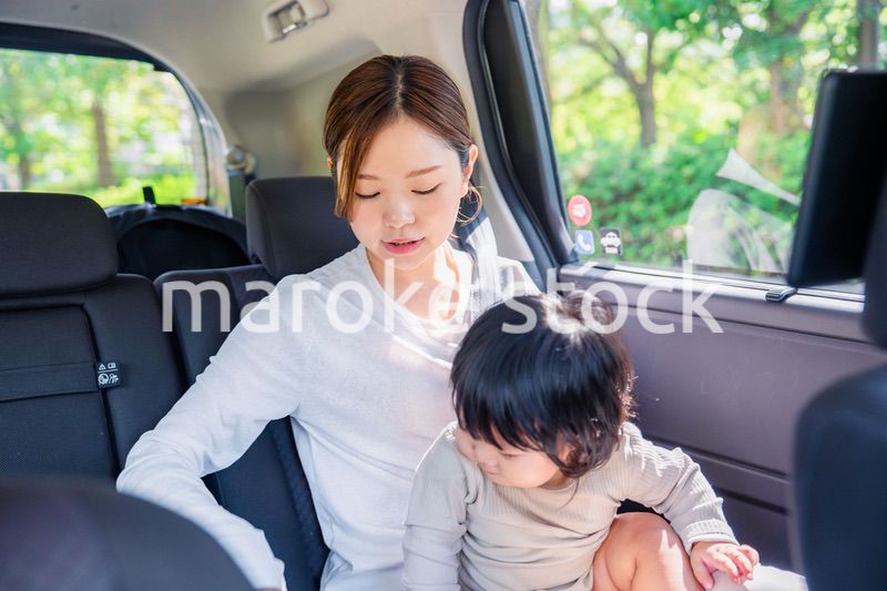 タクシーでシートベルトをする子連れのお母さん