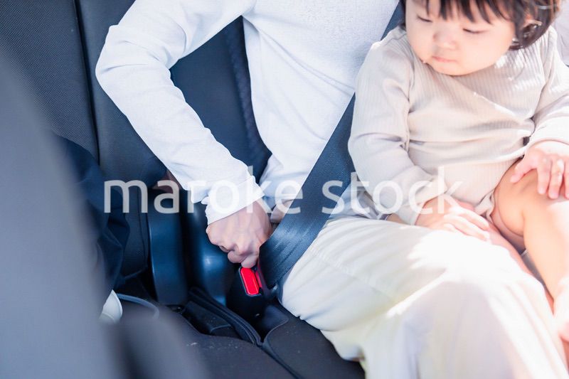 タクシーでシートベルトをする子連れのお母さん