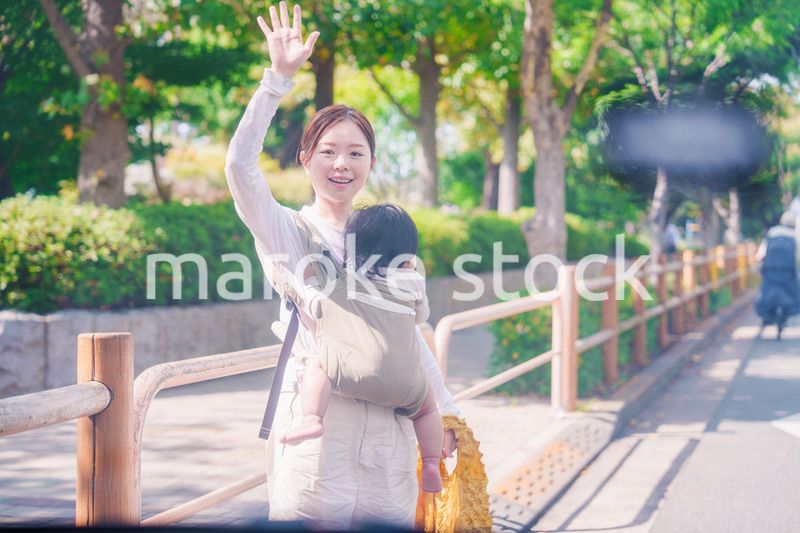 流しのタクシーを止める抱っこ紐をした女性