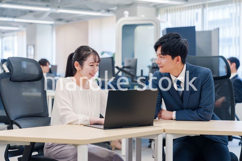 先輩社員から業務を教えてもらう新人の女性