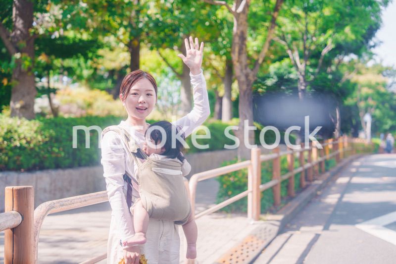 流しのタクシーを止める抱っこ紐をした女性