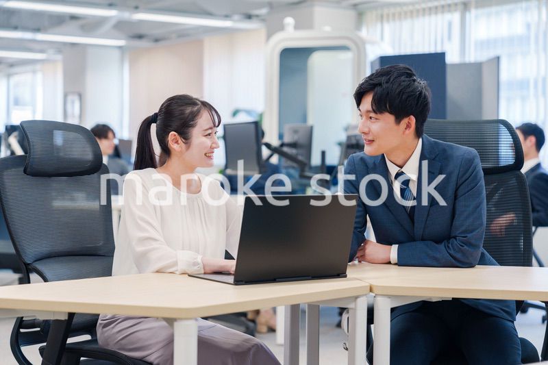 先輩社員から業務を教えてもらう新人の女性