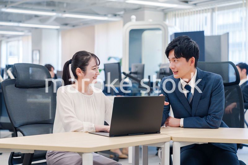 先輩社員から業務を教えてもらう新人の女性