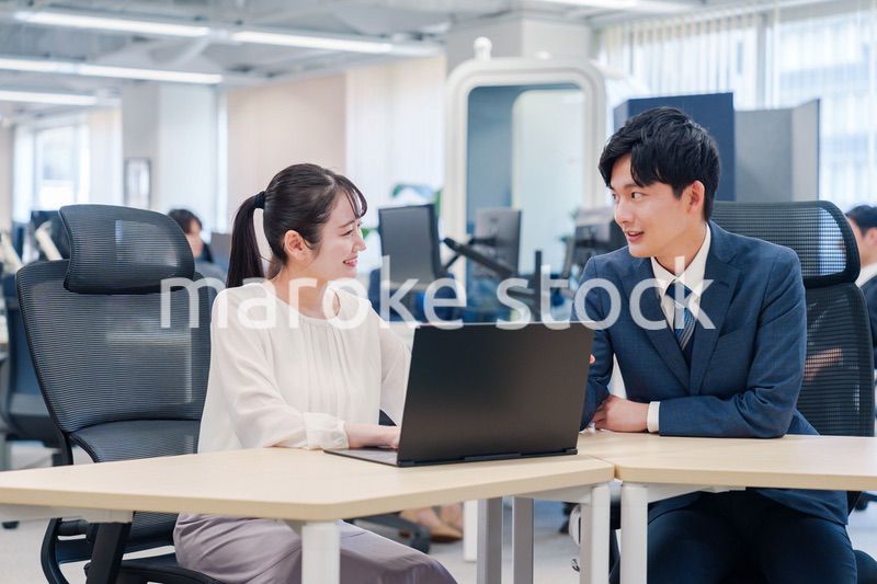 先輩社員から業務を教えてもらう新人の女性