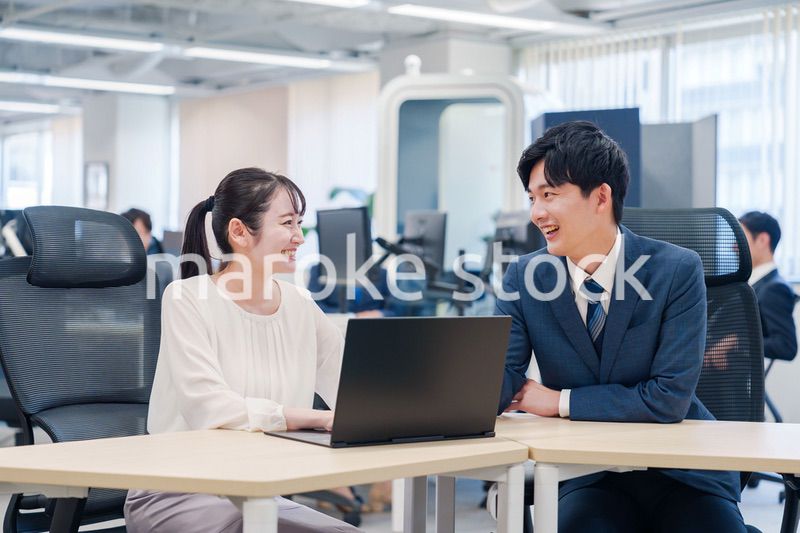 先輩社員から業務を教えてもらう新人の女性