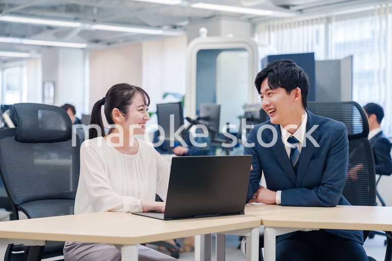 先輩社員から業務を教えてもらう新人の女性