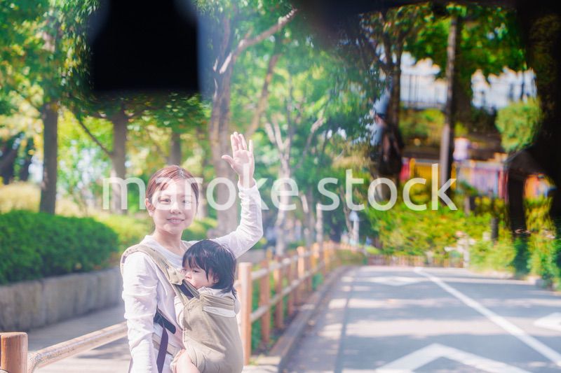 流しのタクシーを止める抱っこ紐をした女性