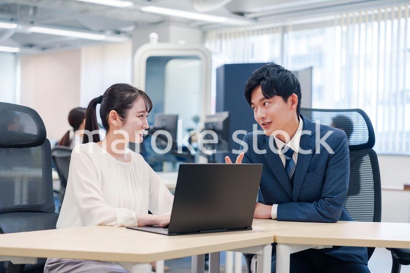 先輩社員から業務を教えてもらう新人の女性