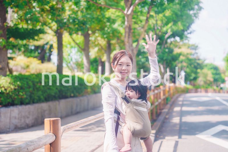 流しのタクシーを止める抱っこ紐をした女性