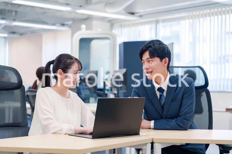 先輩社員から業務を教えてもらう新人の女性