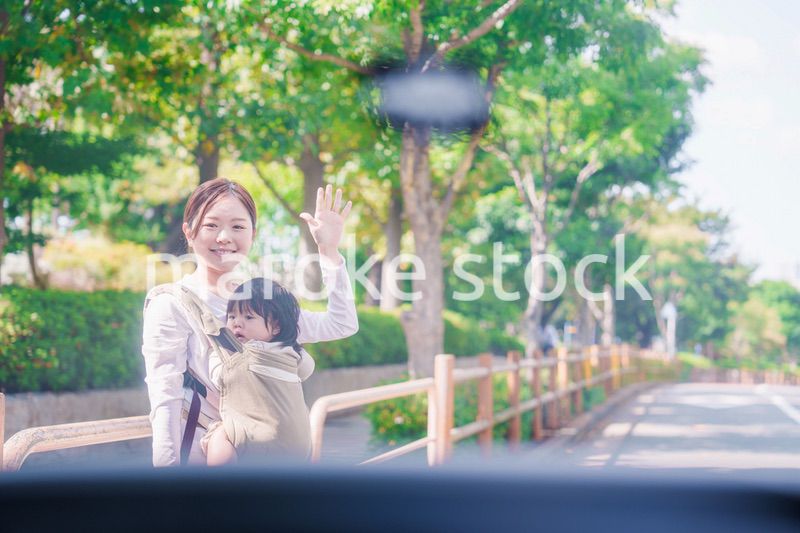 流しのタクシーを止める抱っこ紐をした女性