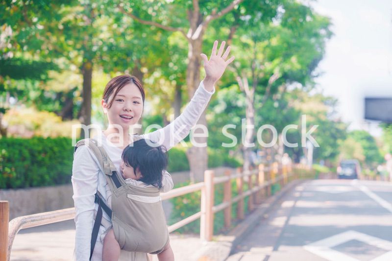 流しのタクシーを止める抱っこ紐をした女性