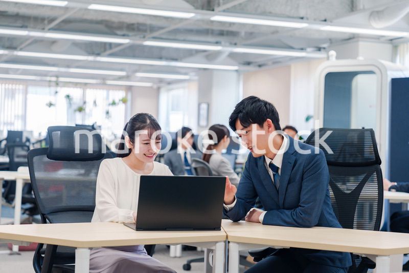 先輩社員から業務を教えてもらう新人の女性