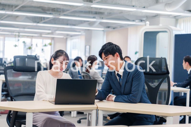 先輩社員から業務を教えてもらう新人の女性